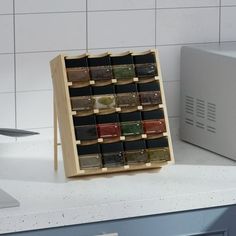 a wooden spice rack on top of a counter next to a microwave and dishwasher