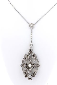 "This platinum necklace comes with a just gorgeous pendant that is covered with pave set diamonds and a white pearl in the center. The chain is 17\" long. The pendant measures 52.8mm long, 30.60mm wide, and sits 6.64mm tall. Perfect for anyone that wants to finish out their Great Gatsby era outfit. B383FLOSPM --Please reference our policy for more details before purchase-- For International orders, please provide a phone number for shipping purposes. Just place a note in the comment box during c Antique White Gold Necklace With Pearl Pendant, Bridal Pendant Necklace With Single Cut Diamonds, White Platinum Pendant Necklace, Silver Diamond Pearl Necklace For Evening, Elegant Wedding Necklace With Large Pendant, Elegant Large Pendant Necklace For Wedding, Ornate White Gold Necklace With Diamond Accents, Exquisite Diamond Necklace With Pearl Pendant, Ornate Formal Necklace With Pearl Pendant