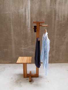 a wooden bench with clothes hanging on it