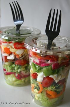 two mason jars filled with salads and forks