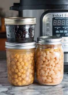 three jars filled with beans next to an instant pot