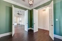 an empty room with green walls and white doors