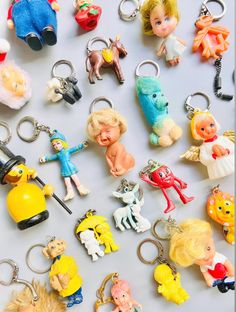 many different toy key chains on a white surface with one being an angel and the other is a boy