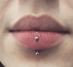 a woman's lips with piercings on the tip of her lip and nose