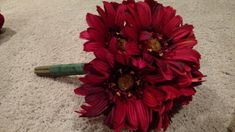 a bouquet of red flowers sitting on the floor in front of a white carpeted area