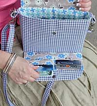 a woman is sitting on the ground with her purse in her lap and holding it open