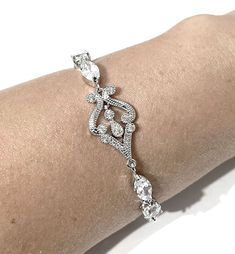 "Bridgerton bridal bracelet featuring Victorian wedding Regency vintage style glam cz motifs made of sparkly clear cubic zirconia in tarnish-resistant silver rhodium plated base. Bracelet length can be made to fit wrist size from 6\" (15cm) and 7\" (18cm). See menu for your own preferred length. We will give a little allowance for your wrist adjustment. Bracelet cz part length is at 4 3/4\" (12cm) and secures with a lobster claw. Width is 1/2\" (1.2cm) at its widest. View matching pieces or simi Elegant Diamond Bracelet With Intricate Design, Classic Cubic Zirconia Crystal Bracelet For Wedding, Elegant Diamond Bracelet For Wedding, Elegant Jewelry With Handset Cubic Zirconia Stones, Elegant Cubic Zirconia Jewelry With Handset Stones, Elegant Wedding Diamond Bracelet, Classic Diamond Crystal Bracelet For Wedding, Elegant Silver Diamond Bracelet With Intricate Design, Classic Crystal Bracelets For Wedding