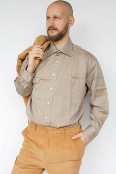 "Brown button up men's shirt Vintage cotton plus size casual formal dress shirt with chest pocket High quality long sleeved cotton shirt, has one chest pocket. Will look great with anything, especially in formal events. In great vintage condition. Measured laying flat - double for circumference: From armpit to armpit: 26\" (66 cm) Length: 33.5\" (85 cm )   Sleeve length: 24\" (61 cm) Tag: Daniel Cremieux, France Model in the photos is size L More from Vintage Finds: https://www.etsy.com/shop/som Formal Shirt With Pockets And Lapel Collar, Formal Shirt With Spread Collar And Pockets, Semi-formal Shirt With Spread Collar And Pockets, Formal Button-up Shirt With Pockets, Collared Business Shirt With Pockets, Office Wear Button-up Shirt With Pockets, Business Button-up Shirt With Pockets, Business Casual Collared Dress Shirt With Pockets, Beige Button-up Business Shirt