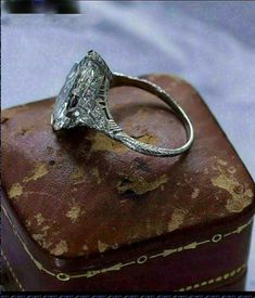 an old diamond ring sitting on top of a suitcase