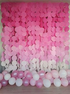 pink and white balloons are hanging on the wall