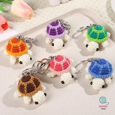 small crocheted turtle keychains on a tray