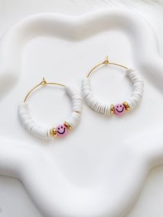 Brighten your outfit with these beautiful smiley heishi bead earrings. ITEM DETAILS  ⭐ 35mm Stainless steel hoops ⭐ Heishi beads ⭐ Acrylic smiley beads ⭐ Stainless steel disc beads CARING TIPS  🤍 Keep your jewelry dry and away from perfumes or any harsh chemicals 🤍 Store your jewelry separately, avoid wearing it if you are going to work out. Thank you so much for visiting my shop! Have fun creating your favorite combinations and enjoy your new jewelry! Preppy Earrings Bead, Cheap Trendy Heishi Beads, Cheap Heishi Beads For Festivals, Clay Disc Earrings, Cheap Heishi Beads For Festival, Affordable Handmade Heishi Beads Earrings, Cheap Handmade Heishi Bead Earrings, Flat Clay Bead Earrings, Clay Bead Hoop Earring Ideas