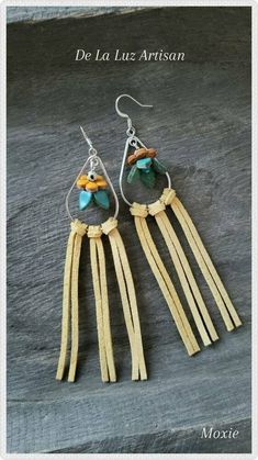 two pairs of earrings with fringes and beads on top of a wooden table next to a