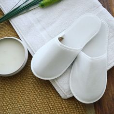 a pair of white oven mitts sitting on top of a table next to a cup