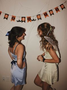 two young women dressed in costumes standing next to each other