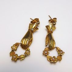 A pair of circa 1830 fine hand made 18K gold earrings depicting hands in jeweled cuffs holding floral wreaths. A rare find on the market today these lovely earrings are entirely handmade. Each delicate earring is set with fine natural seed pearls. These lovely pearls form the jewels on the cuffs and are set at the center of each flower on the beautiful little wreaths the hands are holding. Every part of this earrings is a lifelike miniature. The detail is amazing. Recently I have seen many moder Antique Earrings With 17 Jewels For Ceremonial Occasions, Victorian Pierced Jewelry For Ceremonial Occasions, Vintage Hand Set Yellow Gold Jewelry, Heirloom Evening Jewelry With Matching Earrings, Victorian Evening Earrings With 17 Jewels, Victorian 14k Gold Jewelry With Matching Earrings, Victorian Yellow Gold Clip-on Earrings For Formal Events, Victorian Clip-on Jewelry For Wedding, Victorian Yellow Gold Earrings For Evening