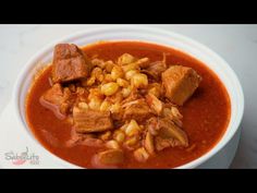 a white bowl filled with meat and corn soup