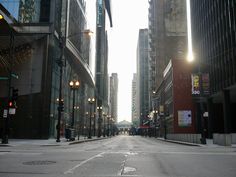 an empty city street with tall buildings in the background