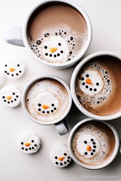 four coffee mugs with hearts on them are sitting in the middle of a table