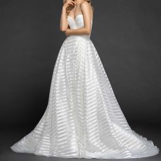 a woman in a white wedding dress posing for the camera with her hands on her chin