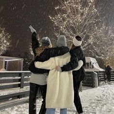 two people are standing in the snow with their arms around each other as they hug