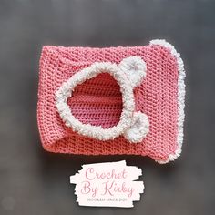 a crocheted pink purse with a white cat on the front and bottom part