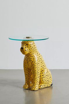 a yellow dog figurine with a glass table top on it's head