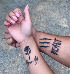 two people holding hands with tattoos on their arms that say beauty and the word love