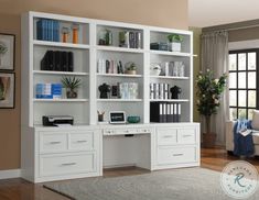 a white bookcase with many books on it in a living room next to a couch