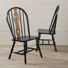 two black and brown chairs sitting side by side on top of a hard wood floor