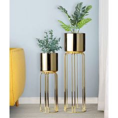 two gold plant stands with plants in them