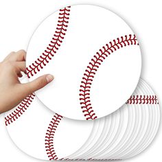 a hand pointing at a set of six baseball coasters