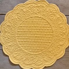 a yellow placemat sitting on top of a wooden table