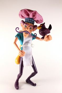 a figurine with an apron and hat on holding a cat in her hand