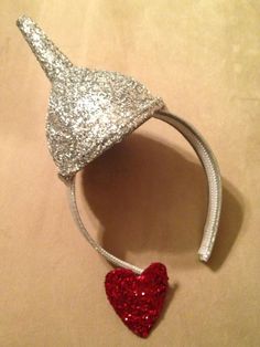 a silver and red glittered headband with a heart on it