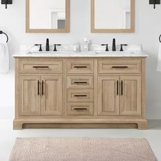 a bathroom with two sinks and mirrors on the wall next to a rug in front of it