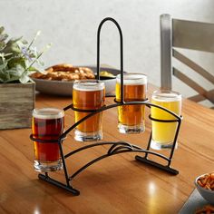 a table topped with glasses filled with different types of beer next to plates of food