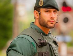 a man in uniform with ear buds on his ears