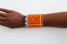 African Maasai beaded bracelets, Maasai Cuff Bracelets, Maasai Wrist bracelets, Beaded bangles, Cuff bracelets, Christmas gift, Moms gift The bracelet is made by the Maasai women in Kenya.  It is beautiful and can compliment any outfit. Available in medium and large size Medium size: fits a standard wrist size of 7.5 inches Large Size: fits a wrist size of 8 to 8.5 inches Shipping fee is for the first item only. Other items ship for FREE! Shipping via DHL Express that takes 3-5 days to be delivered. To view more items from our shop, kindly click here: nkoroicrafts.etsy.com Thank you for visiting! Multicolor Cuff Bracelet For Festivals And Gifts, Orange Bracelets As Festival Gifts, Handmade Orange Cuff Bracelet Bangle, Orange Bracelet For Festivals As Gift, Multicolor Cuff Bracelet As Gift For Festivals, Orange Bracelets For Festivals Gift, Handmade Orange Cuff Bangle, Handmade Orange Bangle Cuff Bracelet, Orange Festival Bracelet As Gift