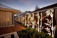 the fence is made out of wood and has laser cut designs on it, along with plants