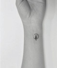 a woman's wrist with a small bird tattoo on the left side of her arm