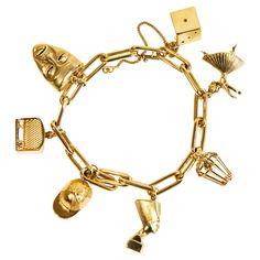 A vintage 14 karat yellow gold chain bracelet with 7 charms, including a dice, a ballerina, a closed basket/cage with a heart inside, Nefertiti, a cap, a radio, and an actor's mask. The bracelet features a safety chain attached to the distal links. The bracelet and the charms were manufactured in the late 20th century. Despite their age, they are in a really good condition with very minor signs of use and of good quality. The bracelet features a cheerful vibe and it is absolutely an eye catcher. Luxury Vintage Gold Charm Bracelet, Gold Chain Bracelet, Gold Charm Bracelet, Safety Chain, Gold Bracelet Chain, Yellow Gold Chain, Late 20th Century, Gold Charm, Radios