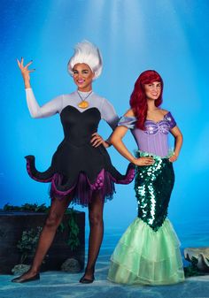 two women dressed as disney princesses pose for a photo in front of an underwater background