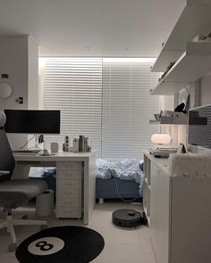 a room that has a bed, desk and chair in it with a black and white rug on the floor