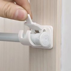 a person is opening the door with a white plastic handle on a wood paneled wall