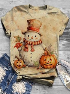 a snowman wearing a top hat and scarf with two pumpkins