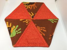 an orange and brown umbrella sitting on top of a table