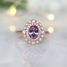 Beautiful Vintage Inspired Alexandrite Ring ►Can be paired with one or two half-eternity Milgrain bands of your choice (select option from a drop menu) ►Base Metal: Sterling Silver (S925) ►Plating: 14K Rose Gold Vermeil ►Accented With Simulated Diamonds Center Stone: Alexandrite Stone Cut: Oval Gem size: 7.0 x 5.0 mm Carat Weight: 0.76 (approx.) Gemstone creation: 100% Genuine Lab-Grown Alexandrite Stone Origin: Russia Hardness: 8.5 (Mohs scale) ►Handling time: 1-2 business days ►Free domestic s Timeless Amethyst Ring With Accent Stones For Wedding, Timeless Amethyst Wedding Ring With Accent Stones, Timeless Amethyst Ring With Center Stone For Wedding, Vintage Halo Promise Ring, Vintage Halo Ring For Promise, Timeless Amethyst Wedding Ring With Center Stone, Vintage Promise Ring With Halo, Heirloom Cluster Ring With Halo For Anniversary, Heirloom 14k Rose Gold Promise Ring