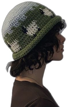 a woman wearing a green and white crocheted hat with stars on the side