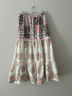 This gorgeous size 10 boho skirt is created from three pieces of vintage preloved sheets. The skirt is tiered from an elasticised waist band and each tier is trimmed with pompom trim.  The skirt also features inseam pockets.  The skirt is ankle length with a soft drape. Thi skirt is a very versatile piece and can be worn comfortably in any weather. Although this style is giving, the ideal measurements are: waist 64-67c, and hips 88-92cm. The skirt is available for $69 with free delivery in Australia Bohemian Tiered Maxi Skirt With Ruffle Hem, Bohemian Maxi Skirt With Ruffle Hem For Vacation, Bohemian Maxi Skirt With Ruffle Hem For Beach, Peasant Style Ruffled Maxi Skirt, Bohemian Maxi Skirt With Ruffle Hem, Tiered Gathered Maxi Skirt For Garden Party, Bohemian Skirt With Ruffle Hem, Bohemian Long Skirt With Ruffle Hem, Peasant Style Tiered Ruffled Maxi Skirt